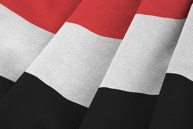 Bandeira do Iêmen com grandes dobras acenando sob a luz do estúdio dentro dos símbolos oficiais e co