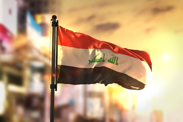 Bandeira do Iraque contra a cidade Fundo borrado no amanhecer Luz de fundo