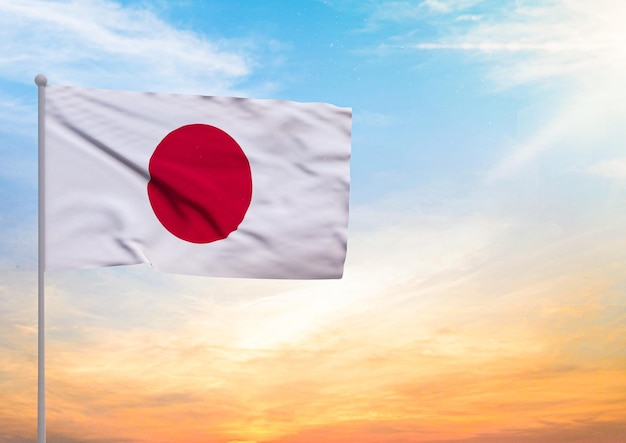 Foto bandeira do japão estendida em um mastro e no fundo um belo céu com um pôr-do-sol