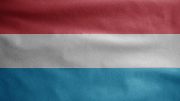 Bandeira do luxemburguês balançando ao vento. Perto da bandeira de Luxemburgo soprando, seda macia e suave. Fundo de estandarte de textura de tecido de pano. Use-o para o dia nacional e o conceito de ocasiões do país.