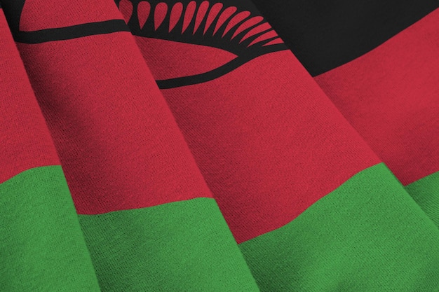 Bandeira do Malawi com grandes dobras acenando de perto sob a luz do estúdio dentro de casa Os símbolos oficiais e cores no banner