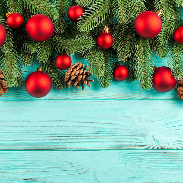 Bandeira do Natal com árvore verde, decorações vermelhas da bola, cones no fundo de madeira da hortelã.