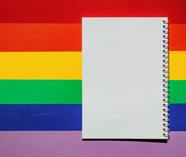 Bandeira do orgulho LGBT com notebook Mockup O fundo de papel colorido é apresentado nas cores do conceito de celebração da bandeira LGBT