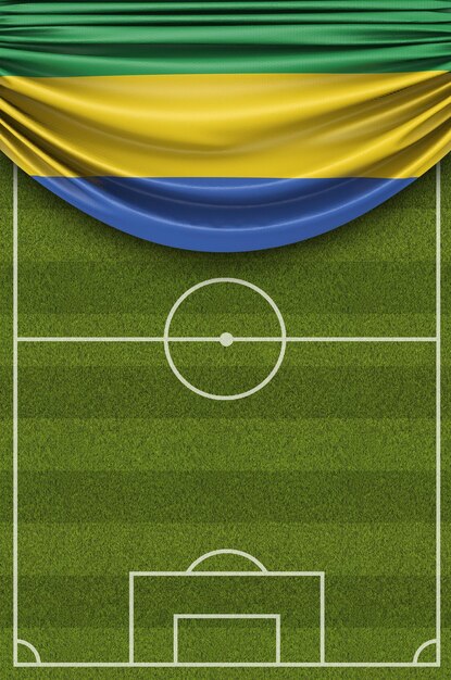 Foto bandeira do país do gabão drapejada sobre um campo de futebol de futebol 3d rendering