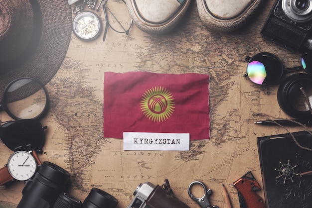 Bandeira do quirguistão entre acessórios do viajante no antigo mapa vintage. tiro aéreo