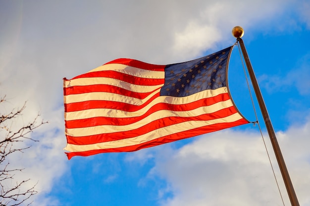 Bandeira dos Estados Unidos balançando ao vento com um lindo céu ao fundo