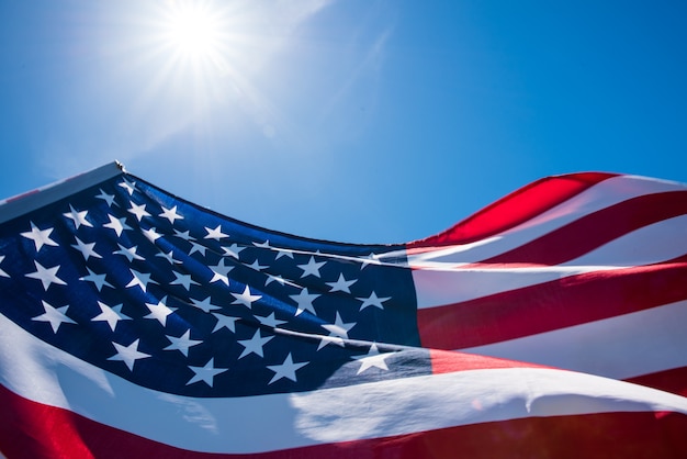 Bandeira dos Estados Unidos da América sobre o fundo do céu azul.