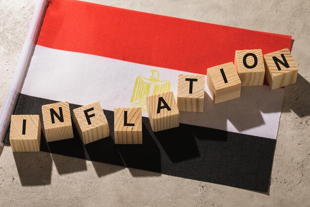 Bandeira egípcia e cubos de madeira com texto, conceito sobre o tema da inflação no Egito