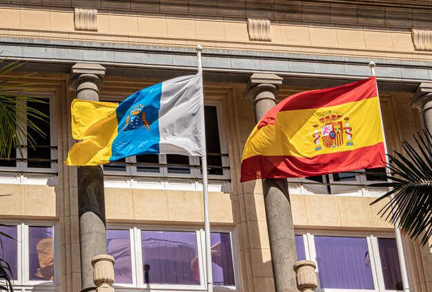 Foto bandeira europeia e espanhola balançando ao vento no palácio do cassino em tenerife