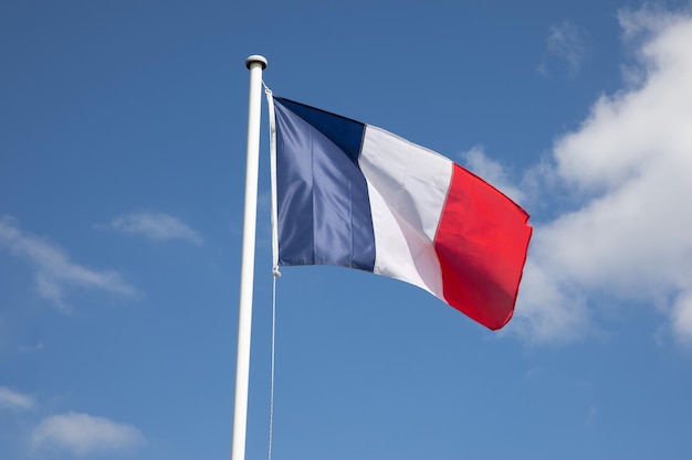 Bandeira francesa da França acenando sobre um céu azul