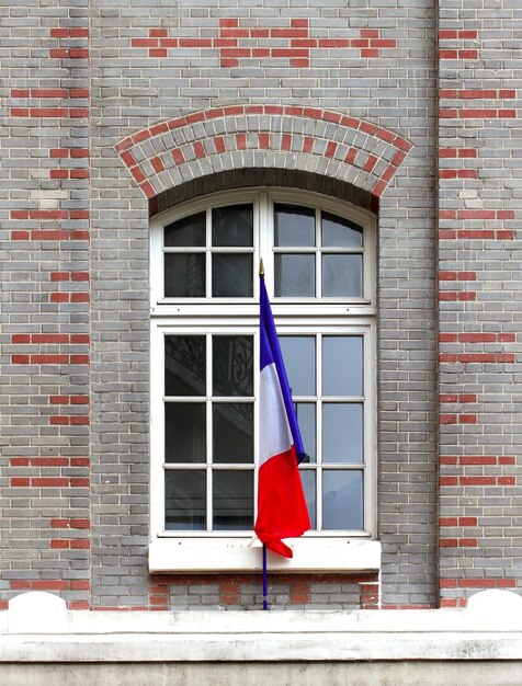 Bandeira francesa na fachada do edifício histórico em Paris