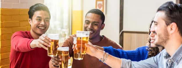 Foto bandeira horizontal ou cabeçalho com amigos felizes bebendo cerveja no bar do pub conceito de estilo de vida multiétnico com pessoas genuínas desfrutando do tempo juntos comendo e bebendo cerveza no colorido bar