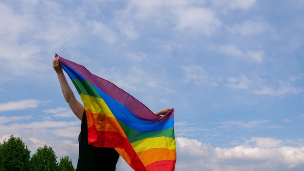 Bandeira lgbt contra o céu azul com nuvens em um dia ensolarado e comemorar o dia da bissexualidade ou comi nacional