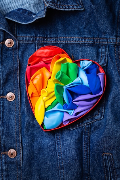 Bandeira lgbtq do arco-íris em forma de coração contra fundo de jeans no mês do orgulho