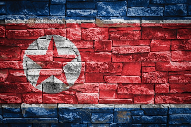 Bandeira nacional da Coreia do Norte em fundo de parede de pedra. Bandeira de bandeira em fundo de textura de pedra.