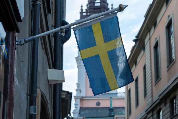 Bandeira nacional da Suécia acenando na fachada de um edifício da cidade de Estocolmo