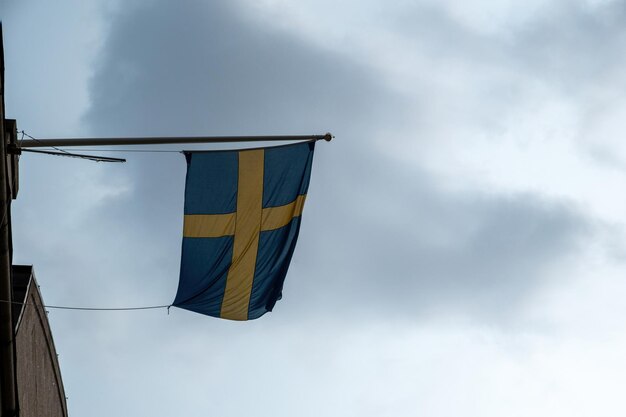 Bandeira nacional da Suécia acenando na fachada de um edifício da cidade de Estocolmo