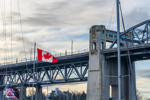 Bandeira nacional do canadá com burrard street bridge em segundo plano vancouver british columbia canadá