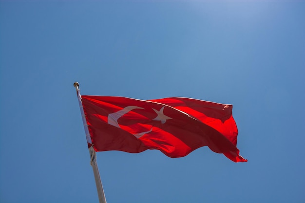 Bandeira nacional turca com estrela branca e lua num poste no céu