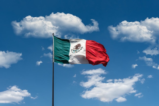 Bandeira oficial nacional do México no fundo do céu azul nublado