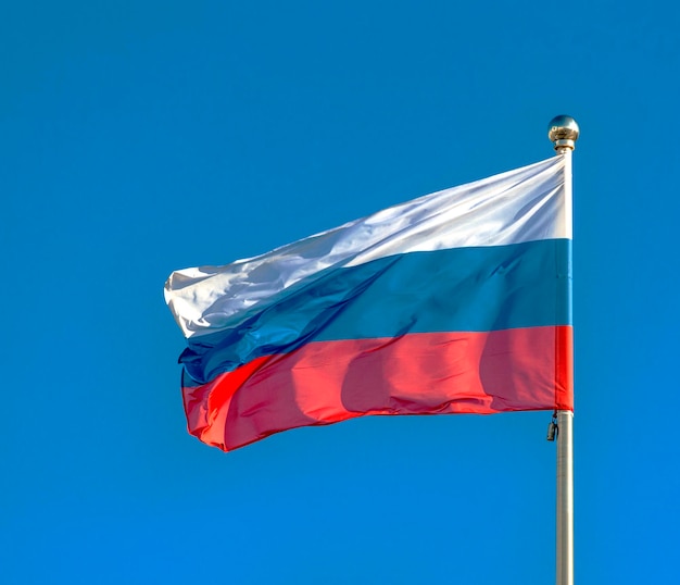 Bandeira russa em um céu azul de fundo