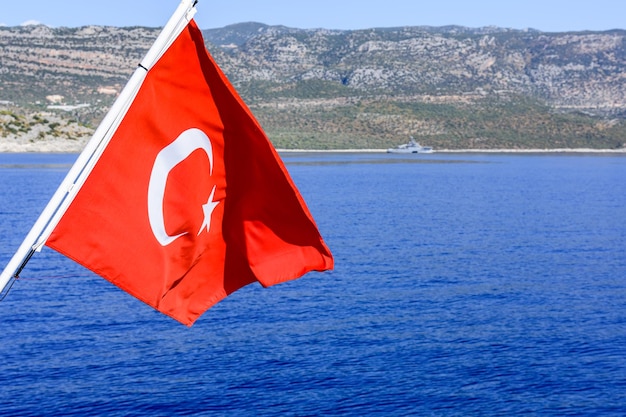 Bandeira turca vermelha tremulando sobre o mar Mediterrâneo