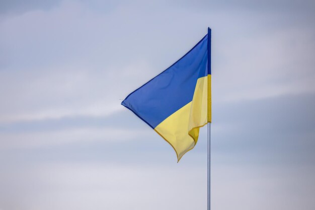 Bandeira ucraniana azul-amarela contra um céu nublado. Símbolos de estado. Valente Ucrânia.