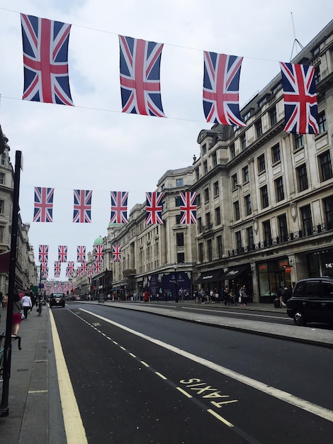 Foto bandeiras britânicas entregando a estrada contra o céu nublado