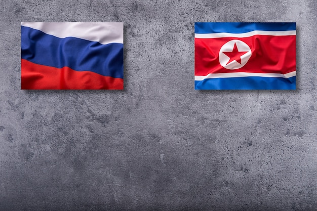 Bandeiras da Coreia do Norte e da Rússia. Bandeira da Coreia do Norte e da Rússia em fundo de concreto.