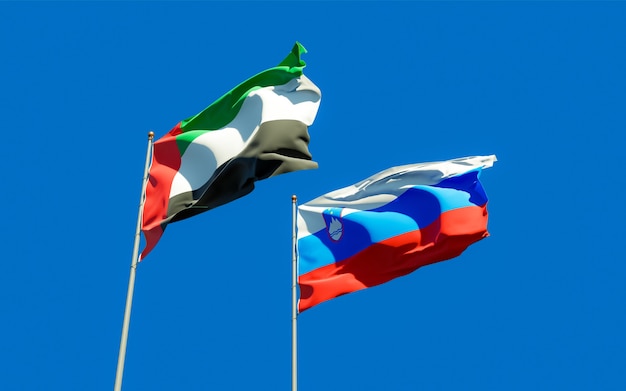 Bandeiras da Eslovênia e dos Emirados Árabes Unidos no céu azul. Arte 3D