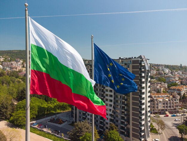 Bandeiras da União Europeia e da Bulgária contra a cidade de Varna no dia de verão