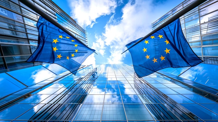 Foto bandeiras da união europeia refletidas em edifícios modernos de vidro contra um céu azul captura o espírito de unidade e identidade europeia ideal para governança corporativa ou conteúdos relacionados com a ue ia