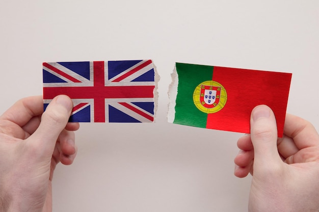 Foto bandeiras de papel do reino unido e portugal rasgaram o conceito de relacionamento político