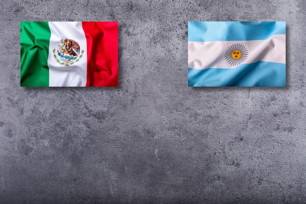 Bandeiras do México e da argentina em fundo de concreto.