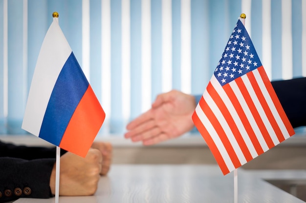 Bandeiras políticas da rússia e dos Estados Unidos da América na mesa na sala de negociação internacional conceito de colaboração de negociações e cooperação de países acordo entre governos