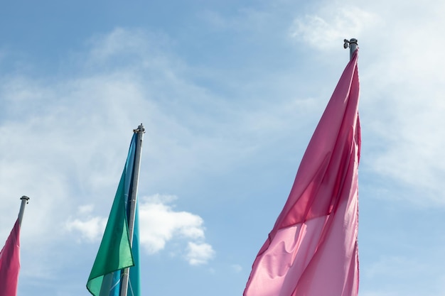 Bandeiras verdes e rosa em um fundo de céu azul copiam o espaço Conceito de fórum político