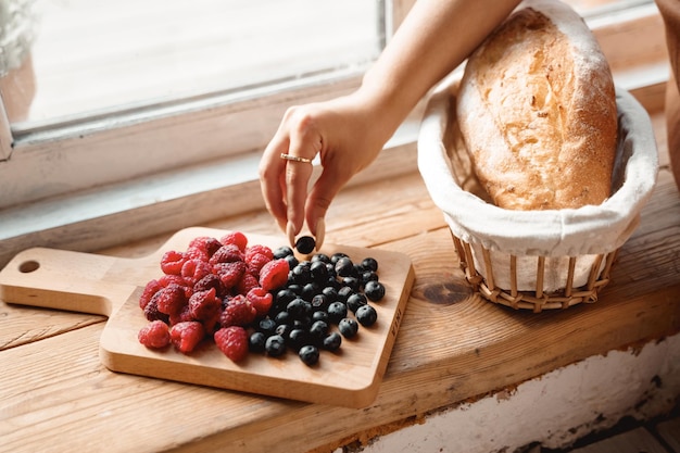 bandeja con bayas en el alféizar de la ventana fresas arándanos