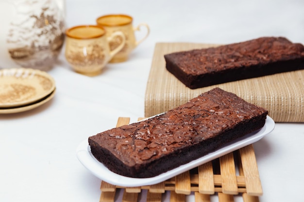 Una bandeja de brownies con una taza de té al lado.