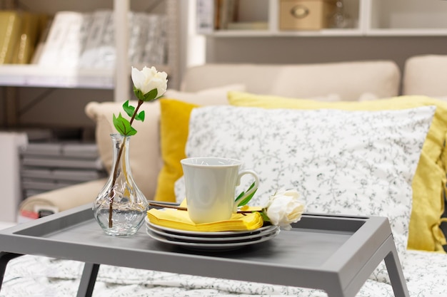 Bandeja cinza com decoração interior de café e flores na cama Café da manhã romântico no conceito de cama