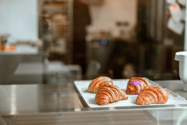 Bandeja com deliciosos croissants frescos em exposição na padaria