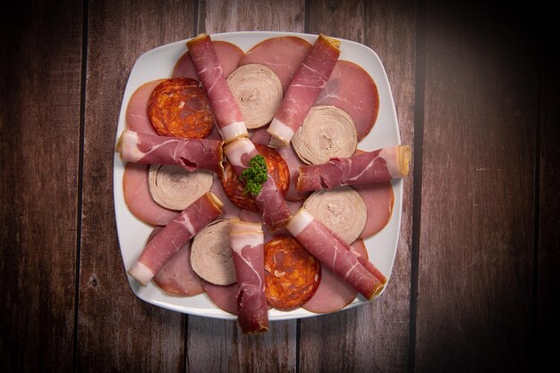 Foto bandeja de comida con delicioso salami pedazos de jamón en rebanadas salchichas carnes deliciosas pepinillos