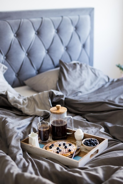 Foto bandeja de madeira com saboroso café da manhã na cama