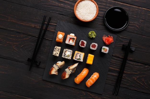 Bandeja de sushi e rolos colorida em restaurante japonês, com vista superior dos pauzinhos.