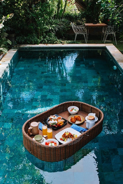 La bandeja del desayuno está flotando en la piscina