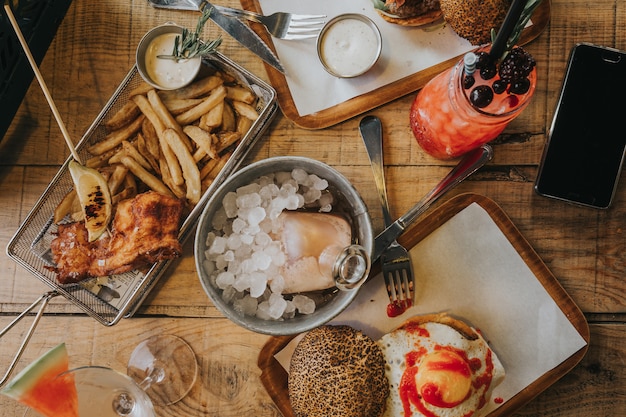 Foto bandeja con hamburguesa y pescado y patatas fritas