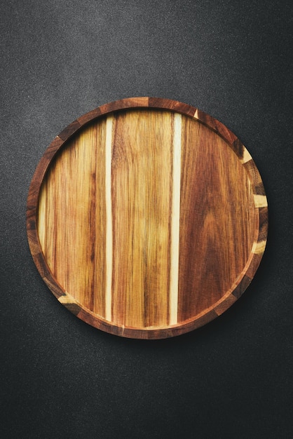 bandeja de madera de cocina o tablero sobre un fondo de piedra oscura vista superior espacio libre para el texto