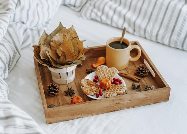 Bandeja de madera con desayuno en la cama