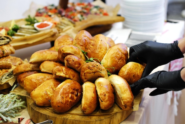 Bandeja de madera con empanadas frescas en la mesa del buffet