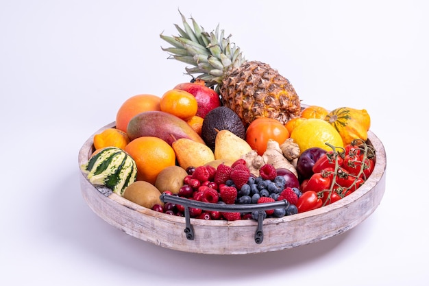 Bandeja de madera de frutas y verduras frescas aislado sobre un fondo blanco rodada en un estudio.