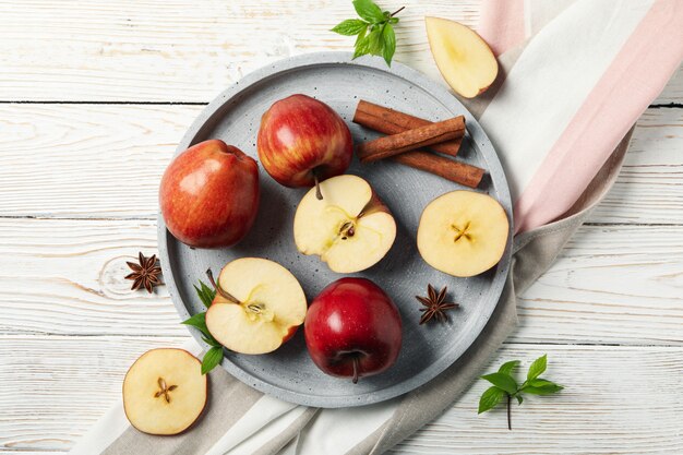 Bandeja con manzana y canela, y toalla en madera, vista superior